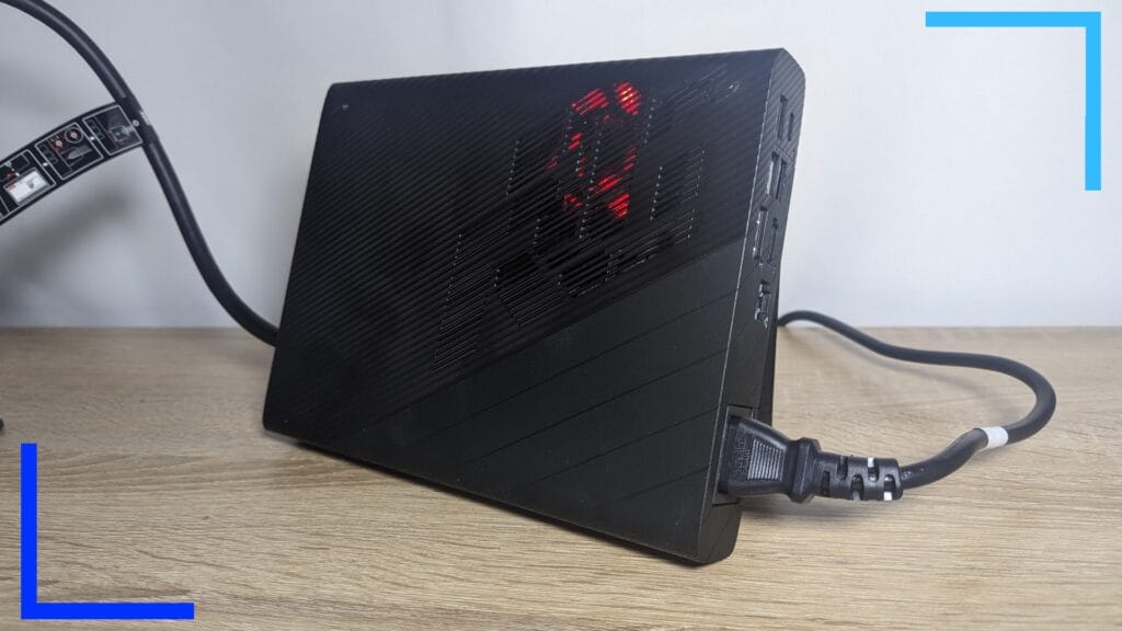Фотография мобильного устройства RTX 4090 XG крупным планом. Сквозь черную внешнюю оболочку можно увидеть красный свет.