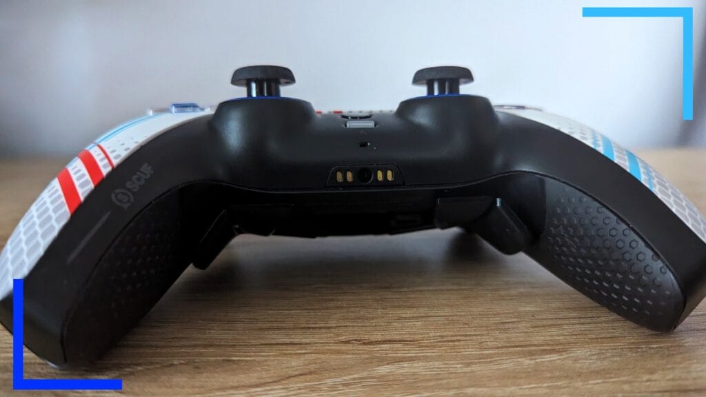 Фотография контроллера Scuf крупным планом снизу: черная нижняя часть с черными джойстиками вверху.