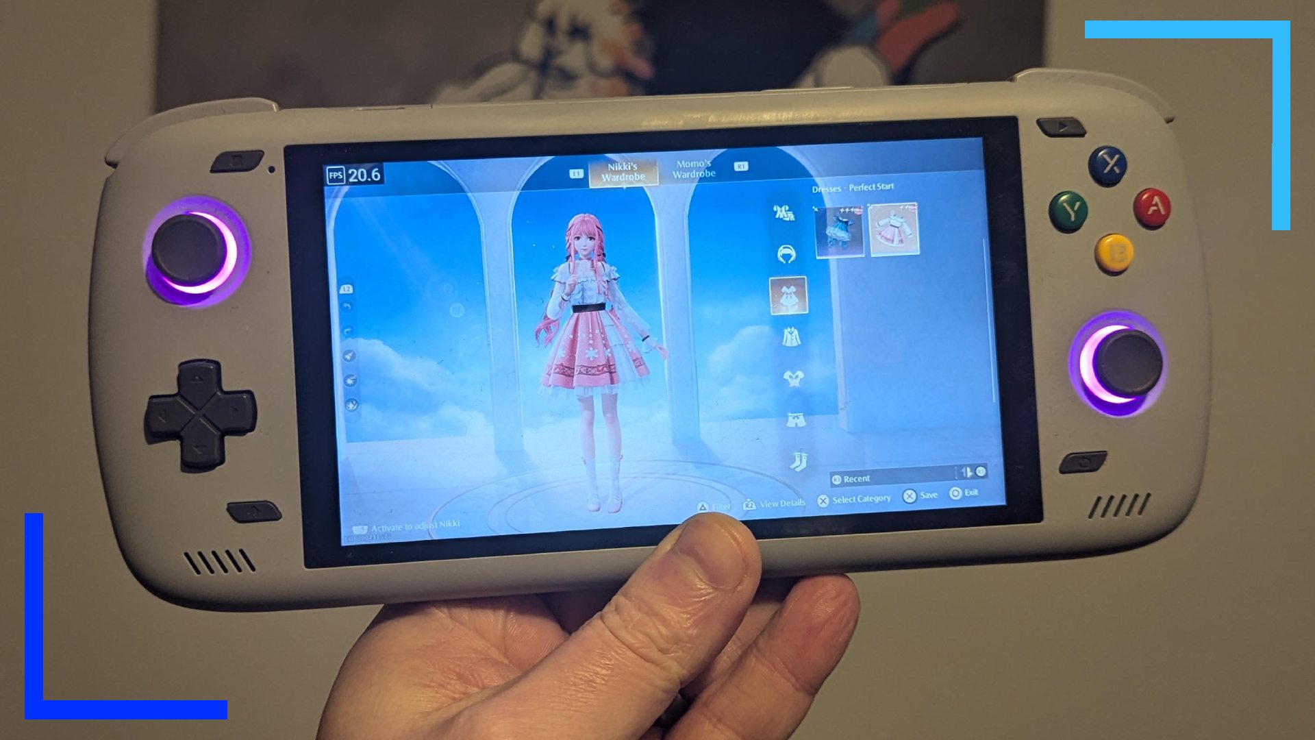 Фотография моей руки, держащей серый Odin 2 с работающей Infinity Nikki на главном экране.